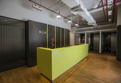 Bright reception area with a lime green front desk and warm wooden flooring.