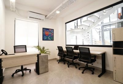 Workplace with multiple black office chairs and a window showing an internal staircase.