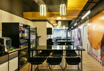Office kitchen area with snack vending machines and high-top dining tables.