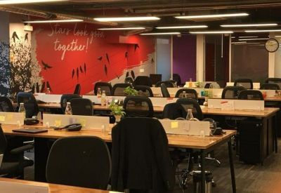 Vibrant open-plan office with a red feature wall reading Stars live here together.