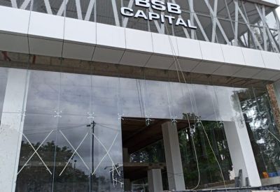 Glass entrance doors beneath a branded building sign and geometric metal architecture.