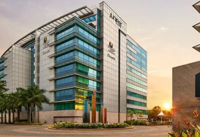 Exterior of a multi-story modern office building with glass windows and signage.