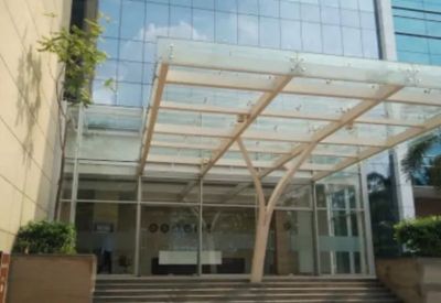 Modern glass entrance canopy with a tree-inspired support structure leading to the lobby.