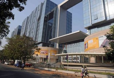 Street-level view of the building entrance with signage and landscaped walkway.