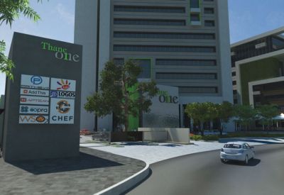 Entrance area featuring a large grey tenant directory pylon and a white car on the driveway.