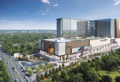 Aerial view of a large commercial complex with a multi-level shopping mall and landscaped entrance.