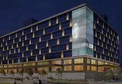 Night view of a multi-story glass office building with glowing interior lights.