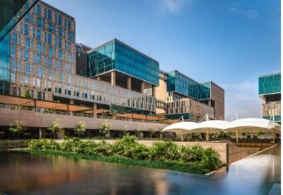 Modern office campus featuring landscaped greenery, reflective water features, and contemporary glass architecture.
