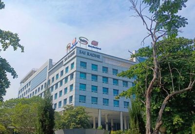 Exterior view of the silver and glass facade at Sai Radhe Corporate Park.