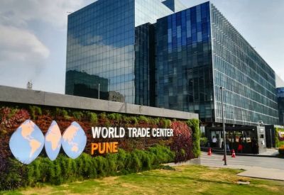 Exterior view of the Redbrick Offices, World Trade Centre, Kharadi with a green living wall and globe logo.