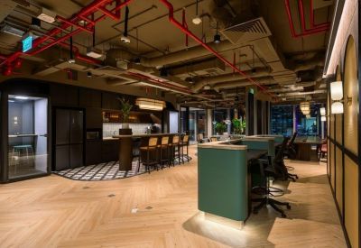 Stylish breakout area with green counters, exposed ceilings, and herringbone floors.