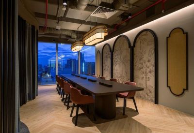 Elegant long meeting table with curved accent wall and evening city views.