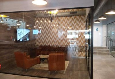 A private meeting room with plush leather seating and chevron patterned wallpaper.