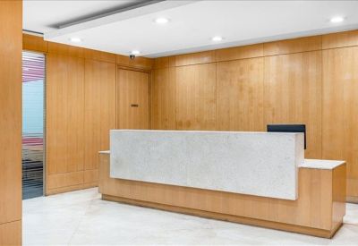 Reception desk featuring a marble-textured front against warm wooden wall paneling.