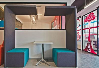 Private glass-walled meeting booths with teal seating and a central white table.