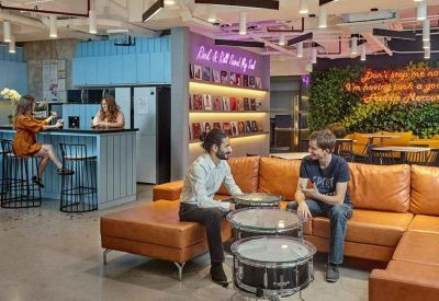 Communal lounge with orange leather sofas and drum-shaped coffee tables.