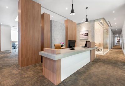 Professional reception desk with wood paneling and minimalist pendant lighting.