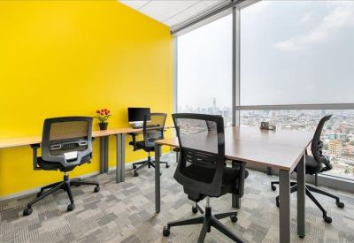 Bright workspace featuring a yellow feature wall and desks with city views.