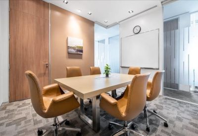 Modern conference room with tan leather chairs and a whiteboard.