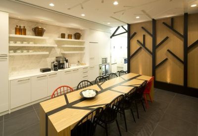 Communal kitchen and dining area featuring a long wooden table with unique black branch patterns.