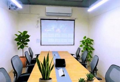 Modern conference room at Rz-4, Dichaon Kalan Road featuring a long wooden table and potted plants.