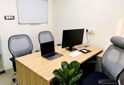 Private office suite with a wooden desk, two guest chairs, and a potted plant.