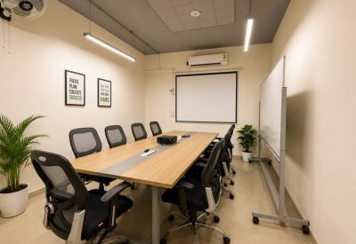 Professional meeting room with a large wooden table and projector screen.