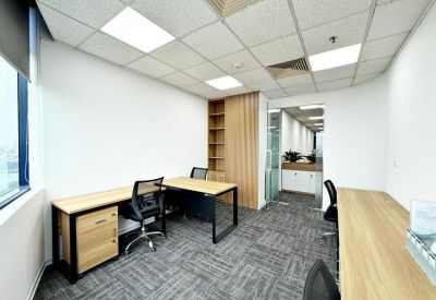 Bright private office with two light-wood desks and ergonomic chairs.