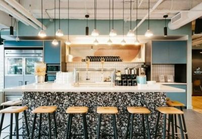 Modern communal pantry with high-top seating and blue cabinetry.