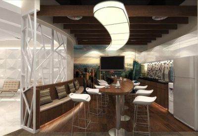 Stylish breakroom with a high wooden bar table, white stools, and unique pendant lighting.