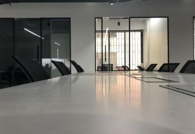 Low angle view of a long white communal desk in a modern open-plan workspace.