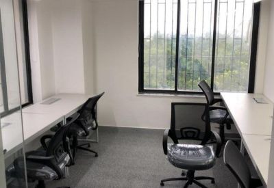 Bright office space featuring workstations next to a large window with greenery views.