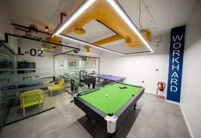 Office recreation room featuring a green felt pool table, ping pong table, and Work Hard wall art.