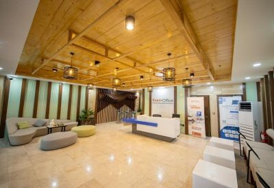 Warm reception area with a wooden ceiling, modern pendant lights, and curved lounge seating.