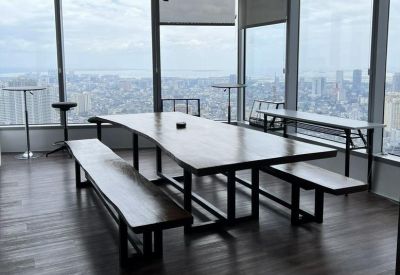 Communal wooden dining table with benches overlooking the city skyline.