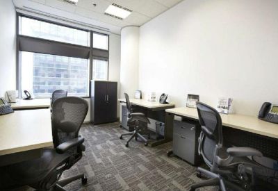 Bright shared office space with multiple workstations and ergonomic mesh chairs.