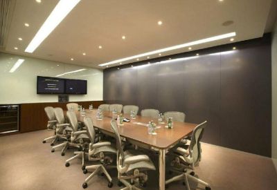 Contemporary meeting room with a long wooden table and ergonomic grey chairs.