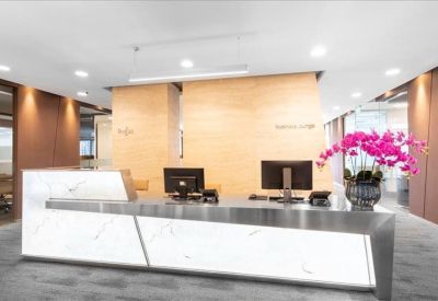 Branded reception desk with a white marble facade and vibrant pink orchids.