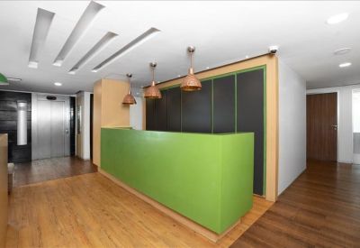 Modern reception area featuring a bright green desk and wooden flooring.