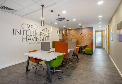 Coworking space with colorful chairs and motivational wall graphics.