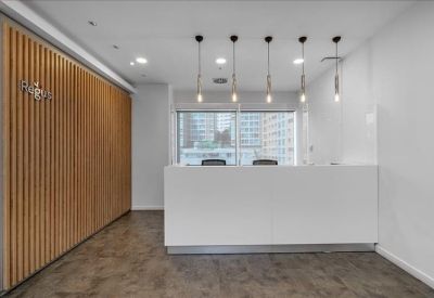Minimalist reception area with a white desk and wood-slat feature wall.