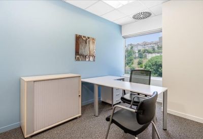 Private office with a blue feature wall and scenic window view.