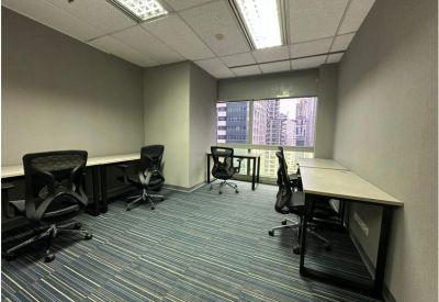 Four-person office suite with light wood desks and blue striped carpet.