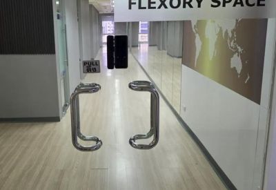 Glass entrance doors with branded signage leading into a modern office corridor.