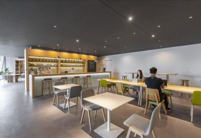 Private wooden work booths with integrated green bench seating and individual pendant lighting.
