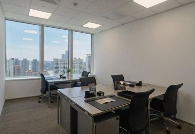 Private windowed office with three workstations and an expansive city skyline view.