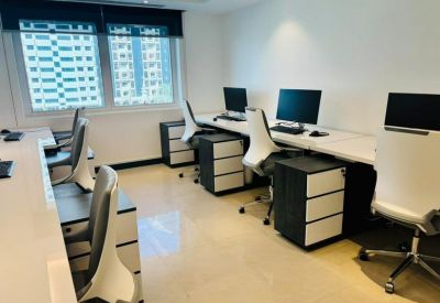 Bright shared office suite with multiple workstations and integrated storage units.