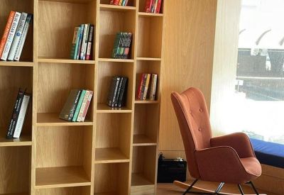 Cozy reading nook with tall bookshelves and a rocking chair.