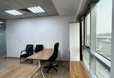 Private office with wooden desks and large window view.