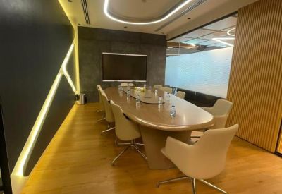 Professional boardroom with an oval wood table and modern lighting.